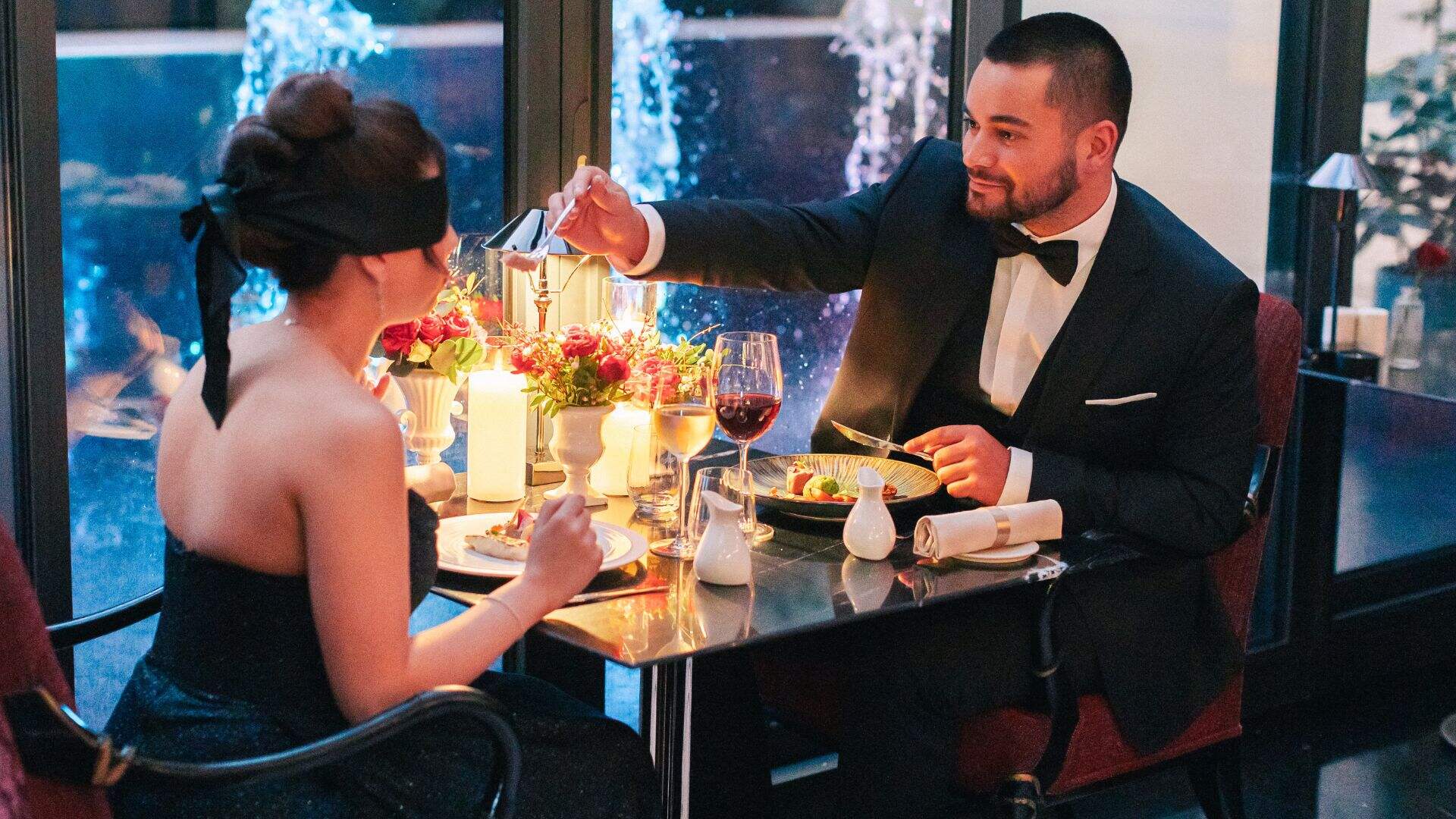 Jeu de dégustation à l'aveugle lors d'un dîner aux chandelles, bandeau sur les yeux